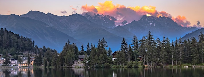 Sunset over the Swiss Alps with mountain silhouettes